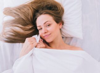 Женщина просыпается с волосами на лице во сне