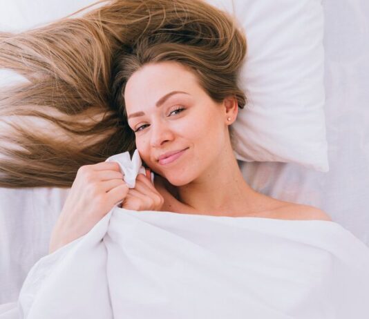 Женщина просыпается с волосами на лице во сне